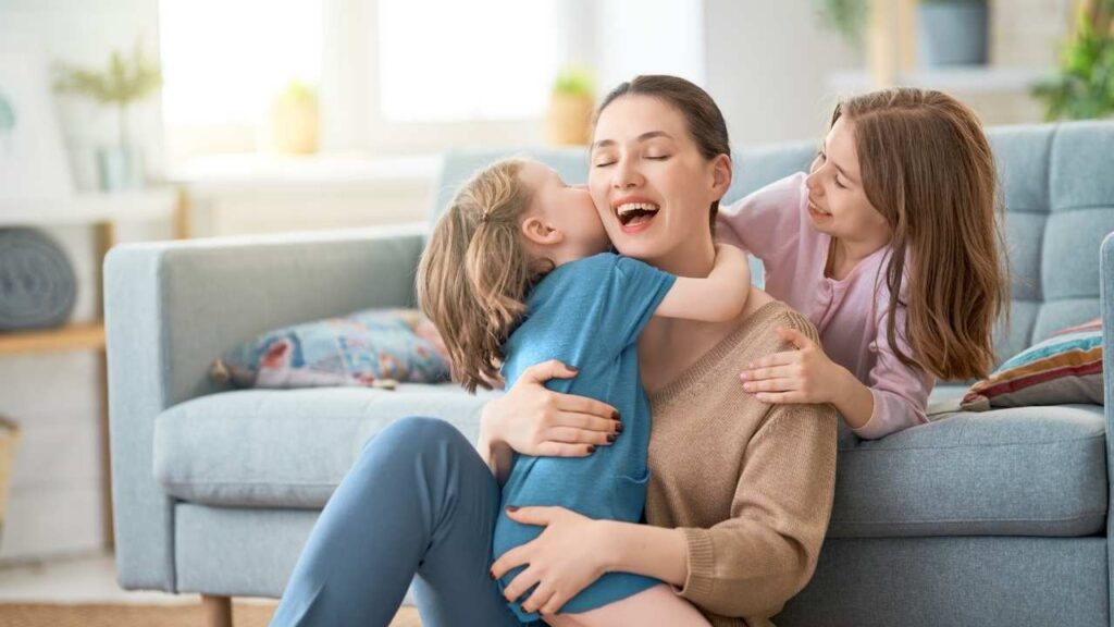 mãe sorrindo com as suas duas filhas