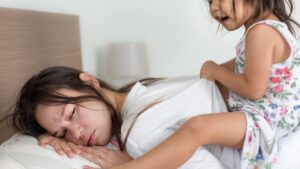 mãe cansada enquanto sua filha esta puxando pelas costas