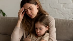 mãe com problemas de traumas na infância enquanto sua filha esta ao seu lado